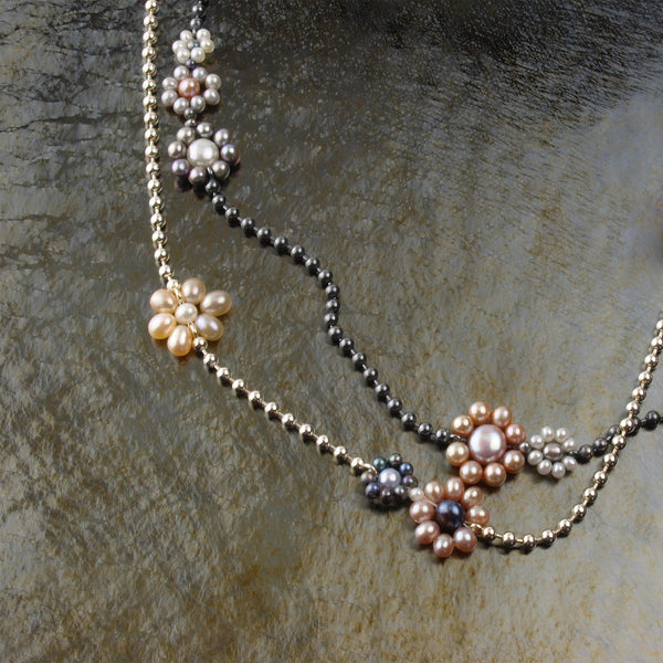 two chain necklaces with freshwater pearl flowers, one is bright Sterling silver and the other is oxidized.