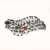 Oxidized Sterling silver chain mail bracelet made of rods and rings. The round connecting rings are 18KY gold. There is a large flower motif on the edge of the bracelet. The border of the bracelet is irregular and the strap lock is visible. The center of the flower is made of bezel set rhodolite garnets and orange sapphires.