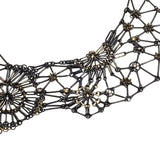 Close up of the Lace Fragment Necklace made of oxidized Sterling silver, 18KY gold, Palladium, yellow Sapphire and Diamond necklace of woven rod links with sections of chain mail flowers in the front of the necklace.