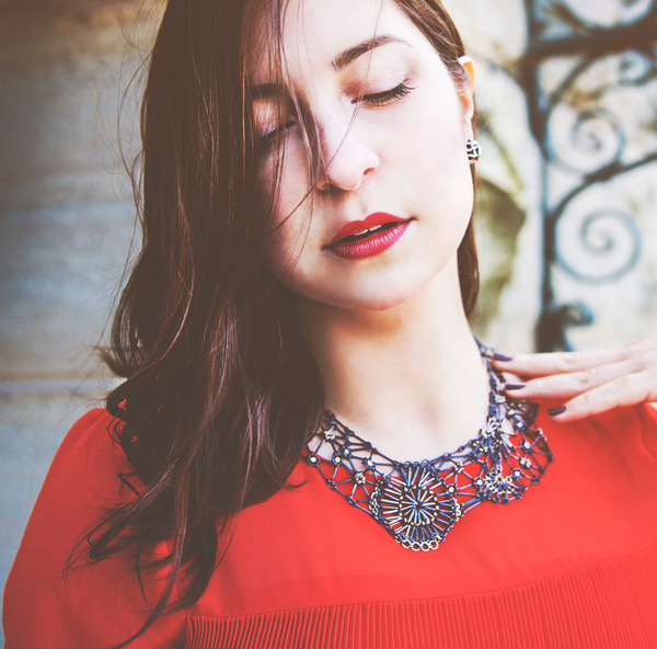 Model wears the Lace fragment Necklace against a red dress.