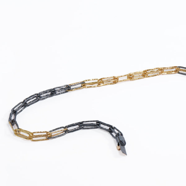 Close up of interwoven 18KY gold and oxidized Sterling silver links with lock.