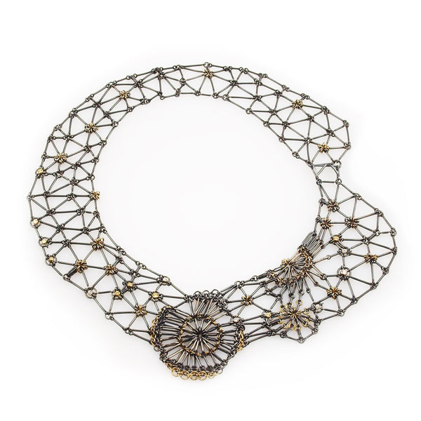 Oxidized Sterling silver, 18KY gold, Palladium, yellow Sapphire and Diamond necklace of woven rod links with sections of chain mail flowers in the front of the necklace.