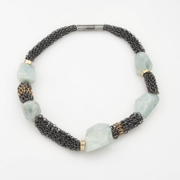 Large aquamarine chunks are strung in between sections of oxidized Sterling Silver chain mail accented with 18KY gold links.