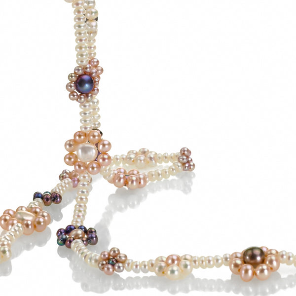 closeup of freshwater pearl happy flowers necklace in white with complimentary pastel colors.