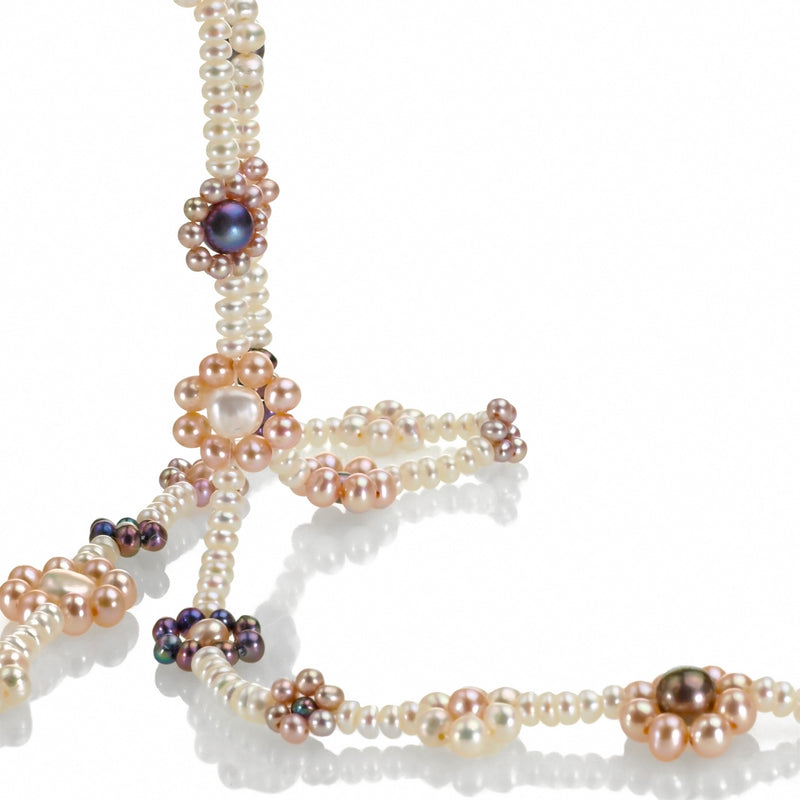 closeup of freshwater pearl happy flowers necklace in white with complimentary pastel colors.