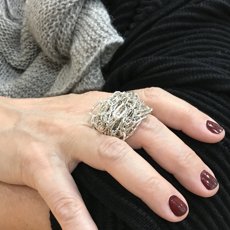 Sterling silver chain maille ring by Carolina Cole shown on a hand.