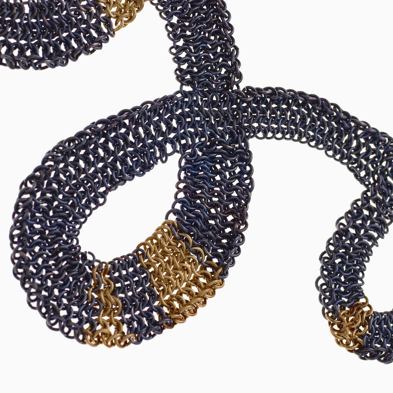 Detail of the SERPENTINE necklace shows hundreds of tiny interwoven rings.